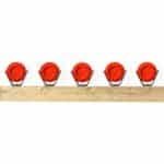 Five AR500 Clay Pigeon Brackets mounted on a horizontal 2x4 beam holding 108mm sporting clay targets